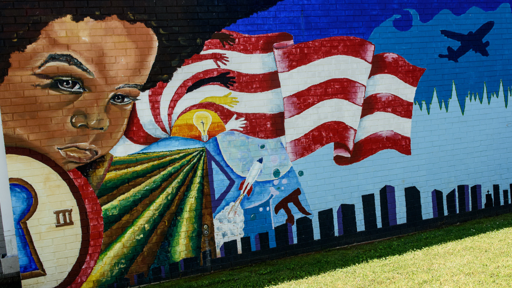 mural of a girl with a flag, rocket and airplane in the background