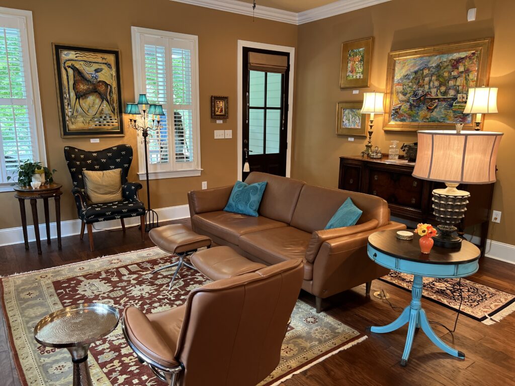 very nice modern living room with leather furniture, teal accents, and art on the wall