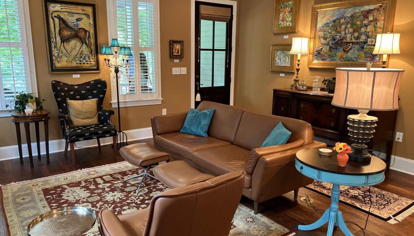 very nice modern living room with leather furniture, teal accents, and art on the wall