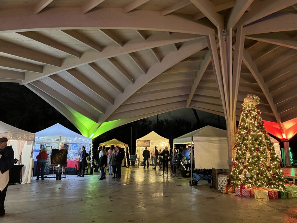 Art booths under an architectural done with a Christmas tree in the center