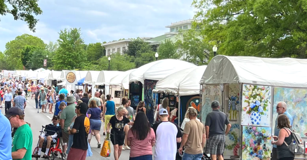 outdoor art market with lots of people shopping