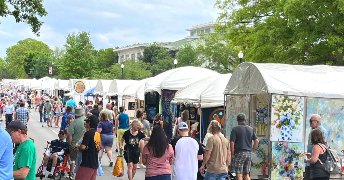 outdoor art market with lots of people shopping