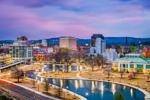 City of Huntsville, AL skyline at dusk with lights reflecting in the lake.