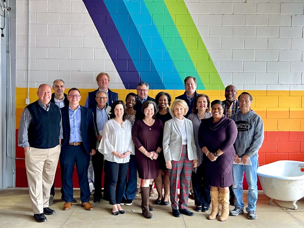 Group of people standing in front of a brightly painted wall