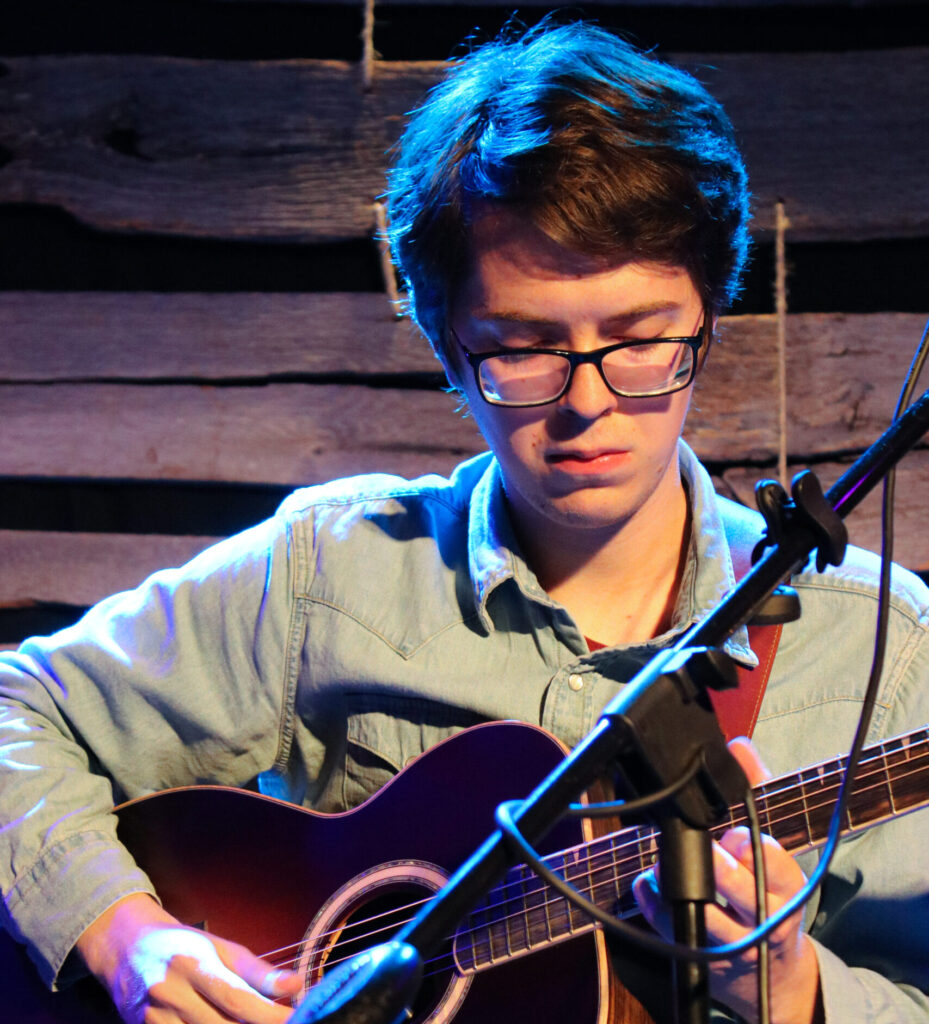 Josh Taylor playing guitar on stage