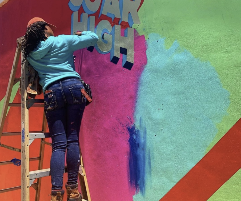 Artist Daria Hammond at work on a mural at Lantana Park.