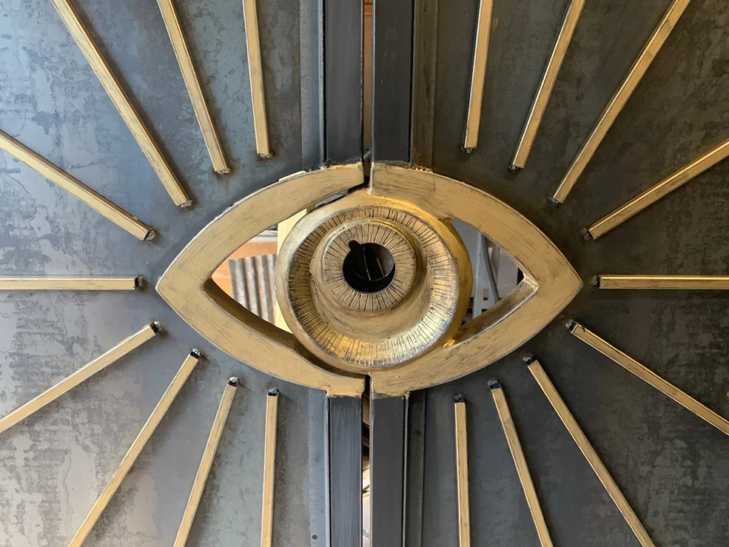 An artistic metal eye surrounded by rays.