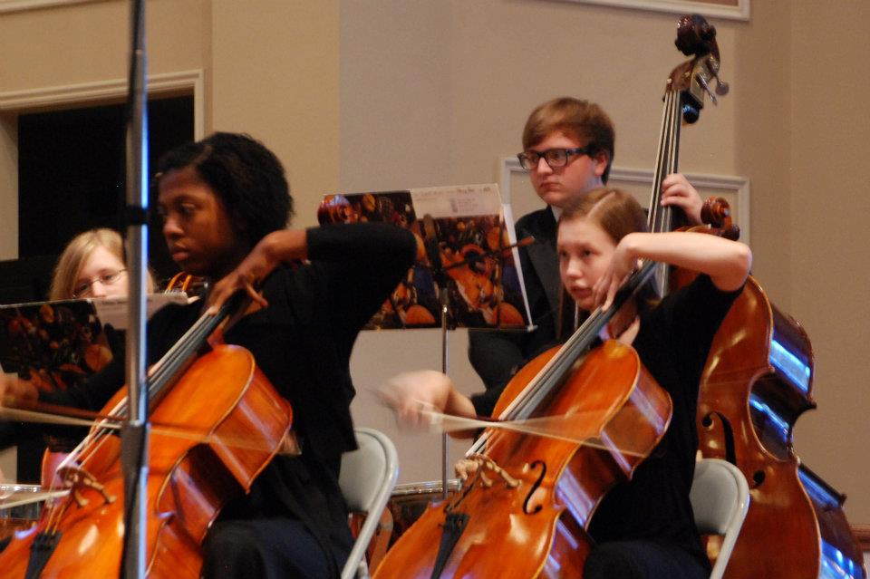 Young cellists performing