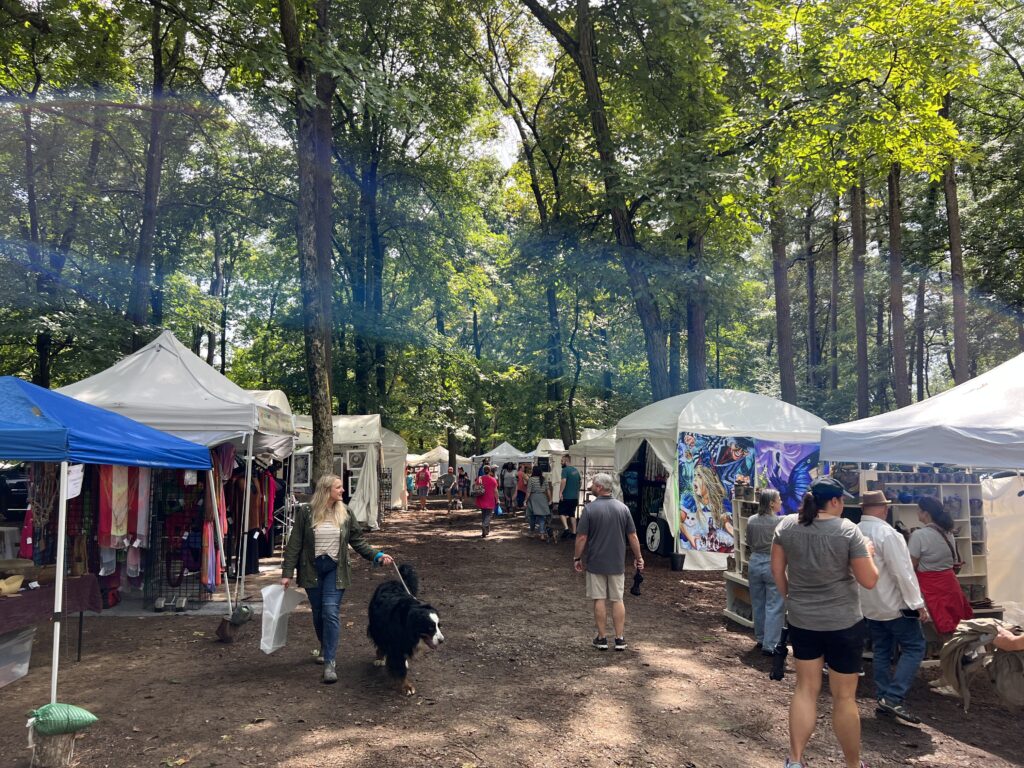 Picture of the artist booths of the Monte Sano Art Festival and people walking through the festival