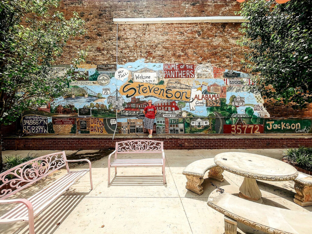 A mural on a brick wall in a courtyard.