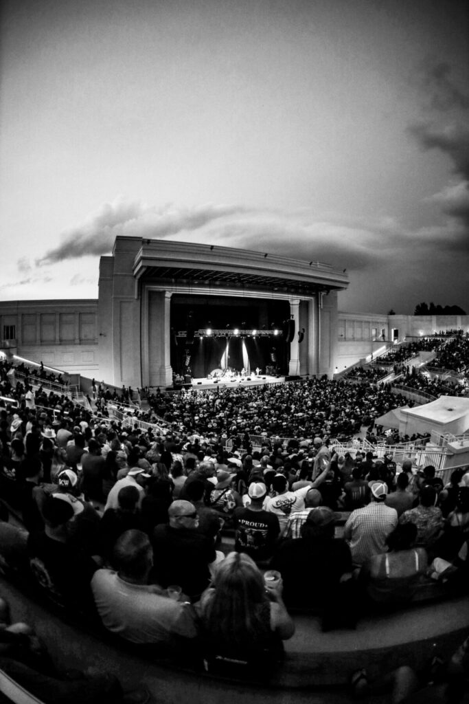 Black and white photograph showing a large crowd watching a performance on the stage of the Orion Ampitheatre in Huntsville, AL